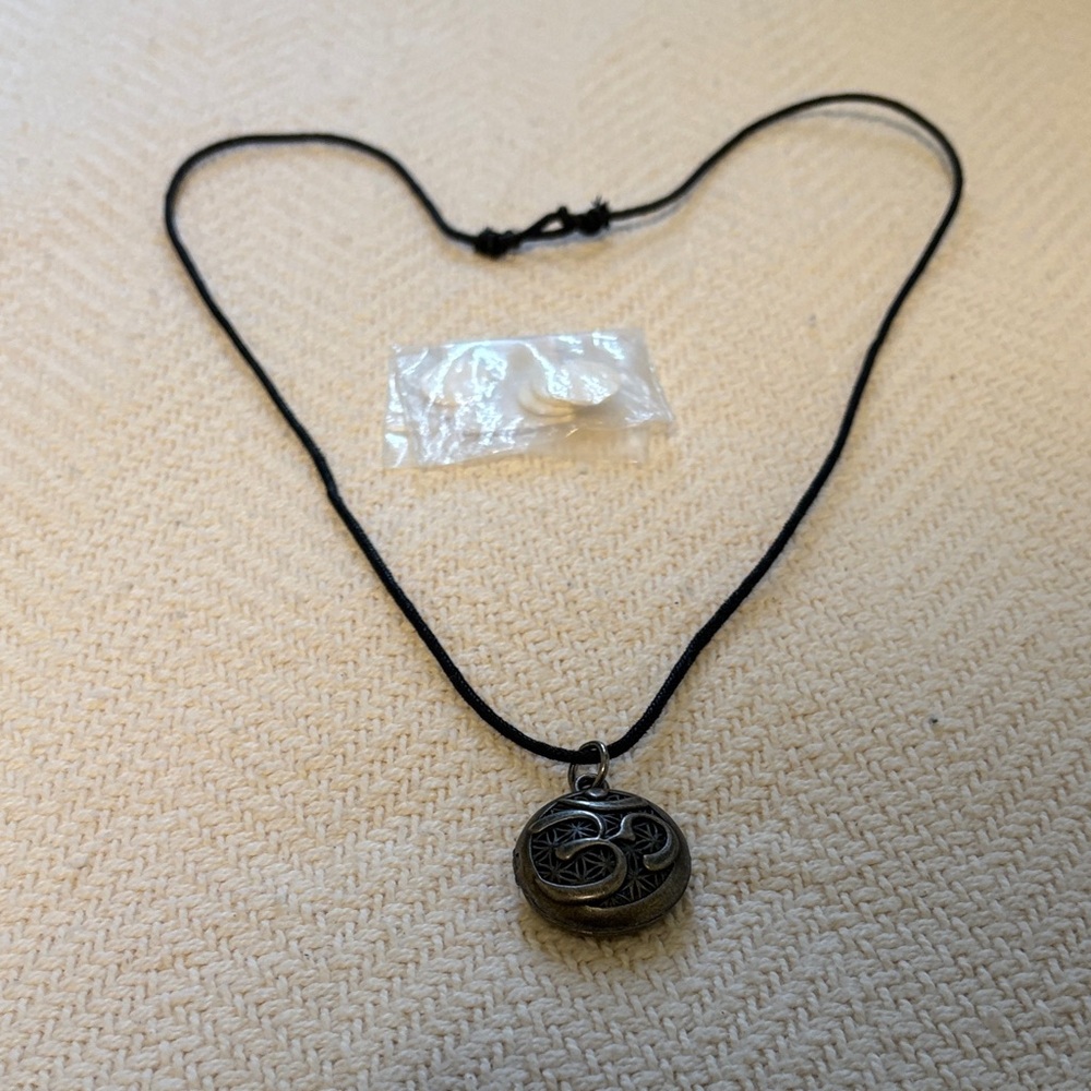 Aromatherapy locket necklace with adjustable strap and four pads for oil.